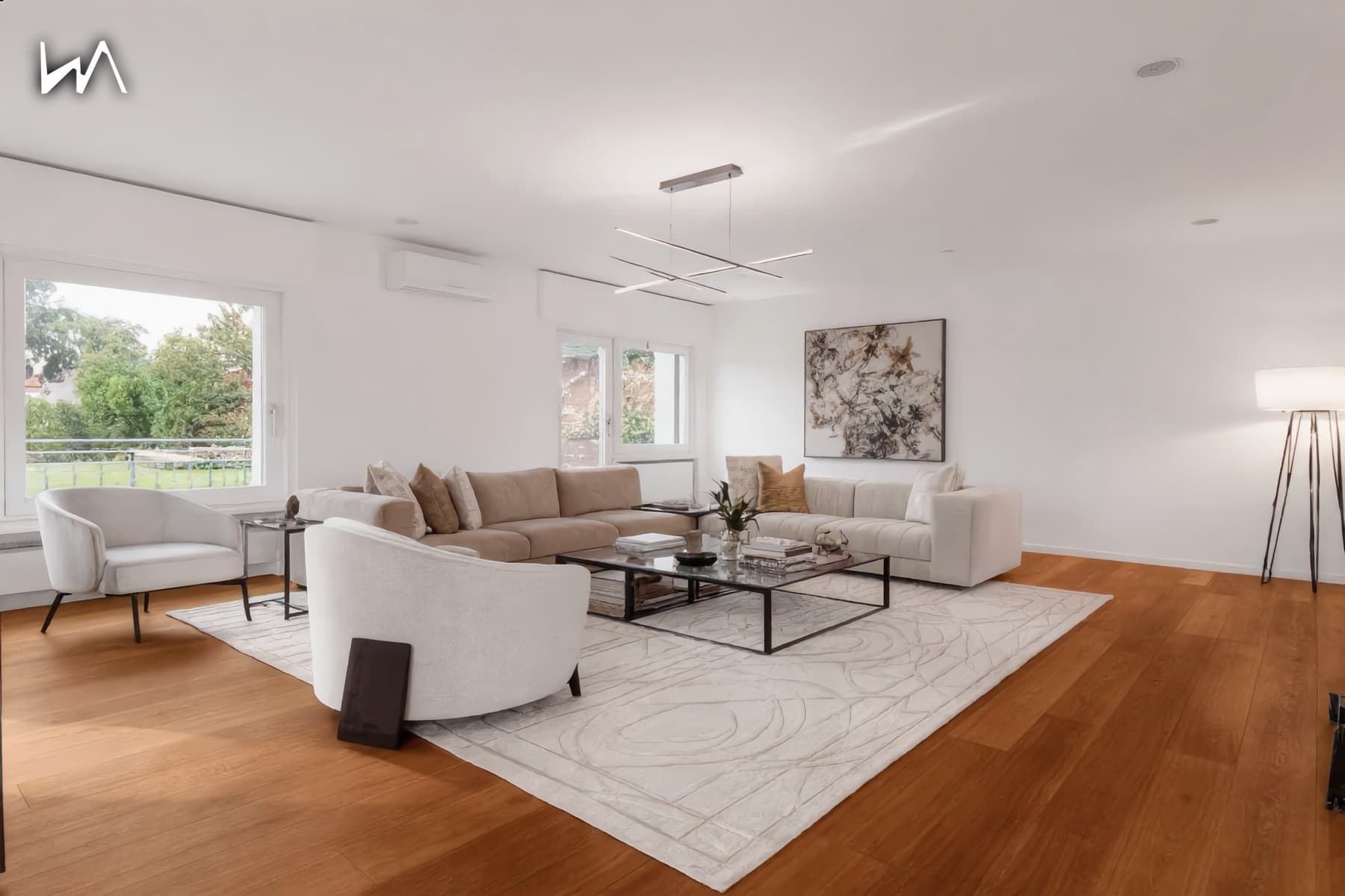 The same living space after virtual staging, furnished with sofas, a rug, artwork and lighting.